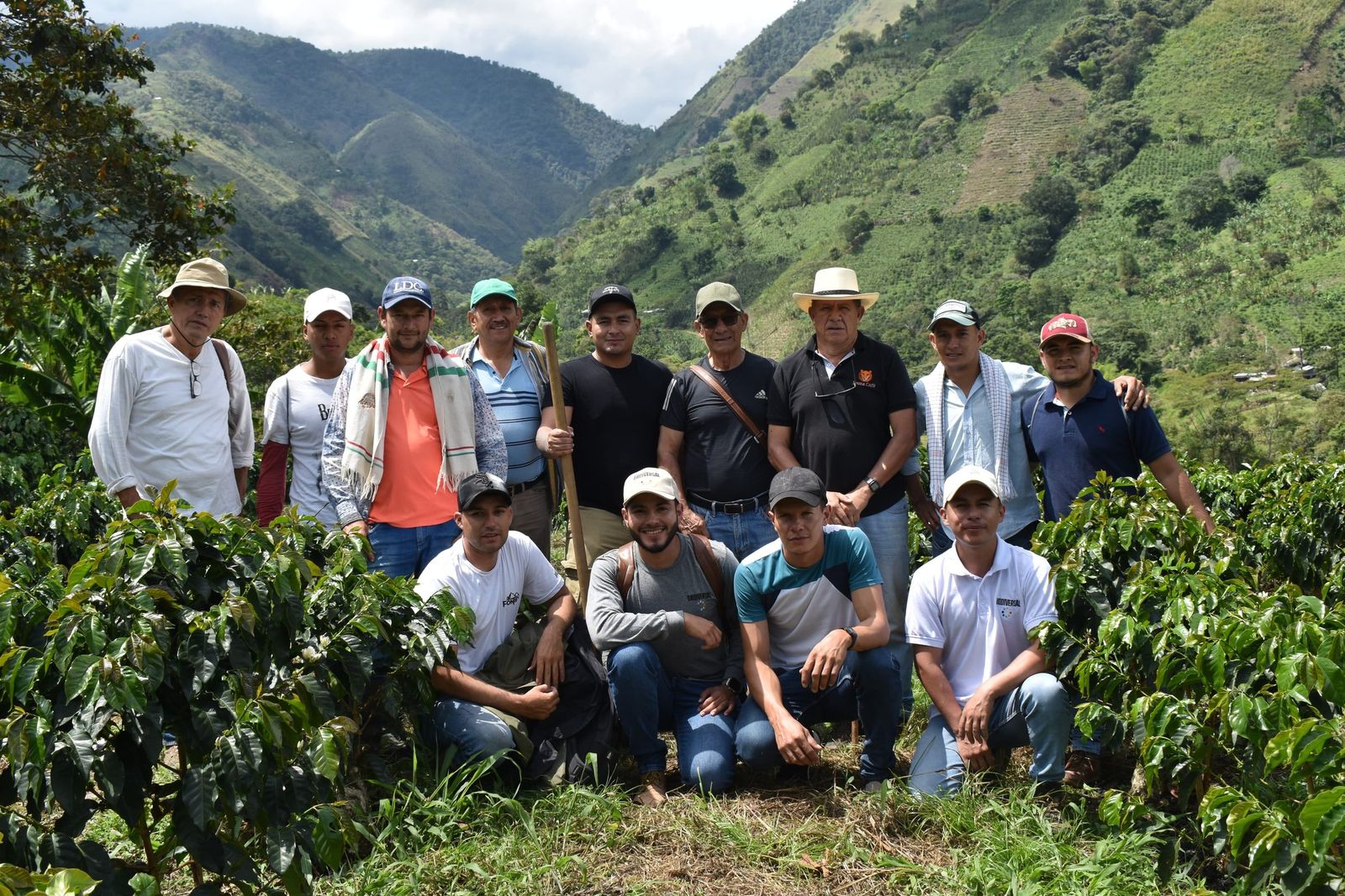 The Cirkular Origin team and growers of the program together on a coffee hillside, with the Andean valley behind them