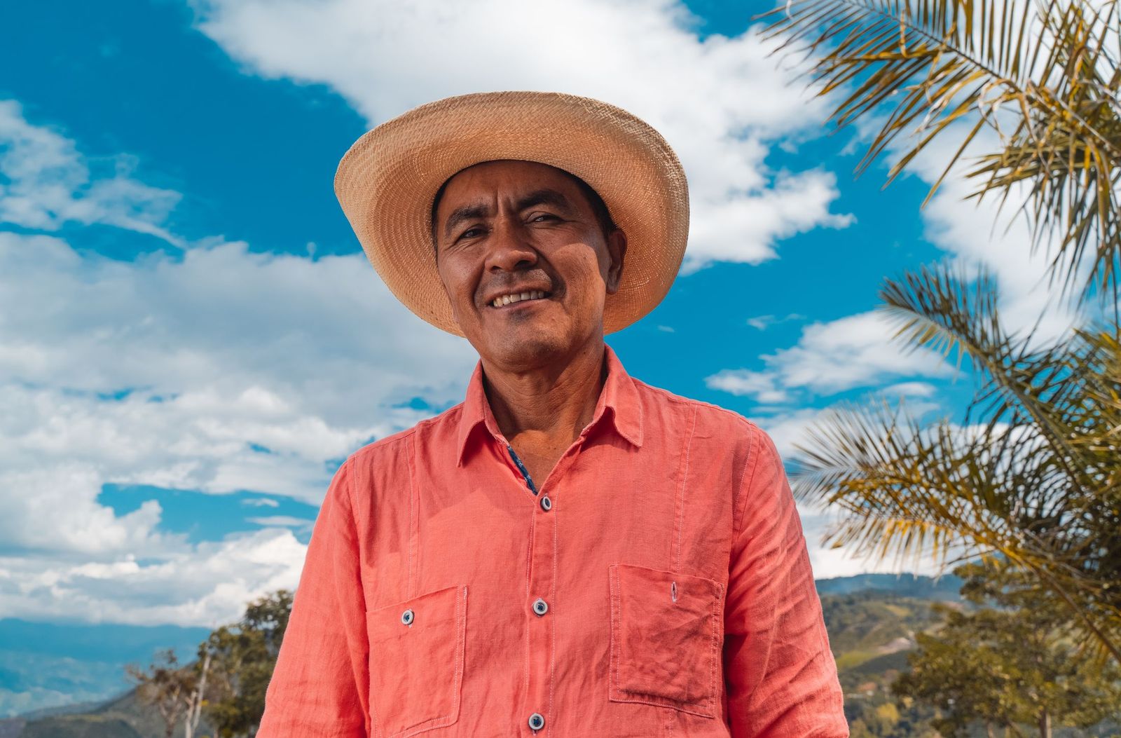 A coffee grower in the program, in a straw hat on his own farm