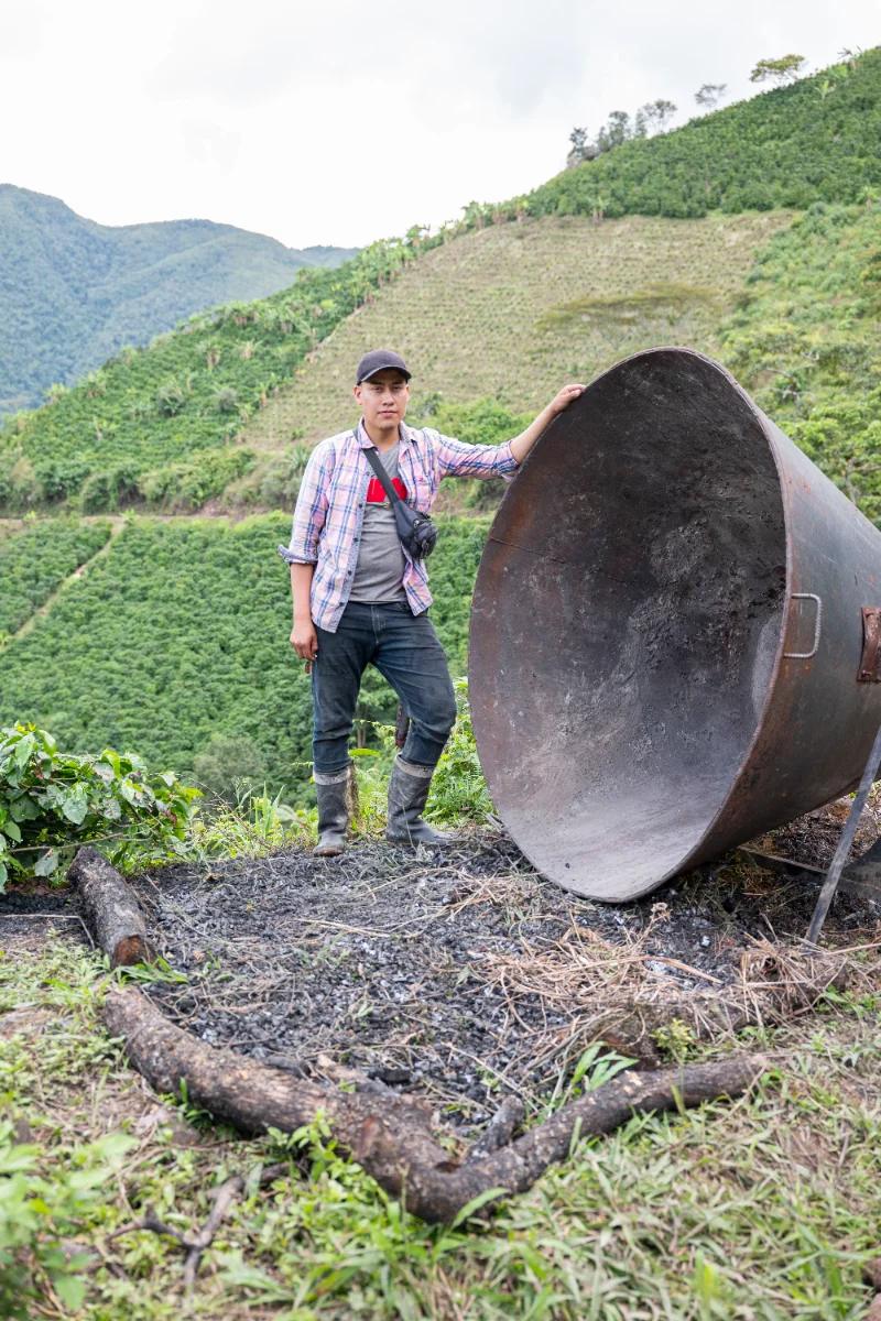 Daniel Perdomo standing beside the kiln on the hillside of his family farm in Planadas