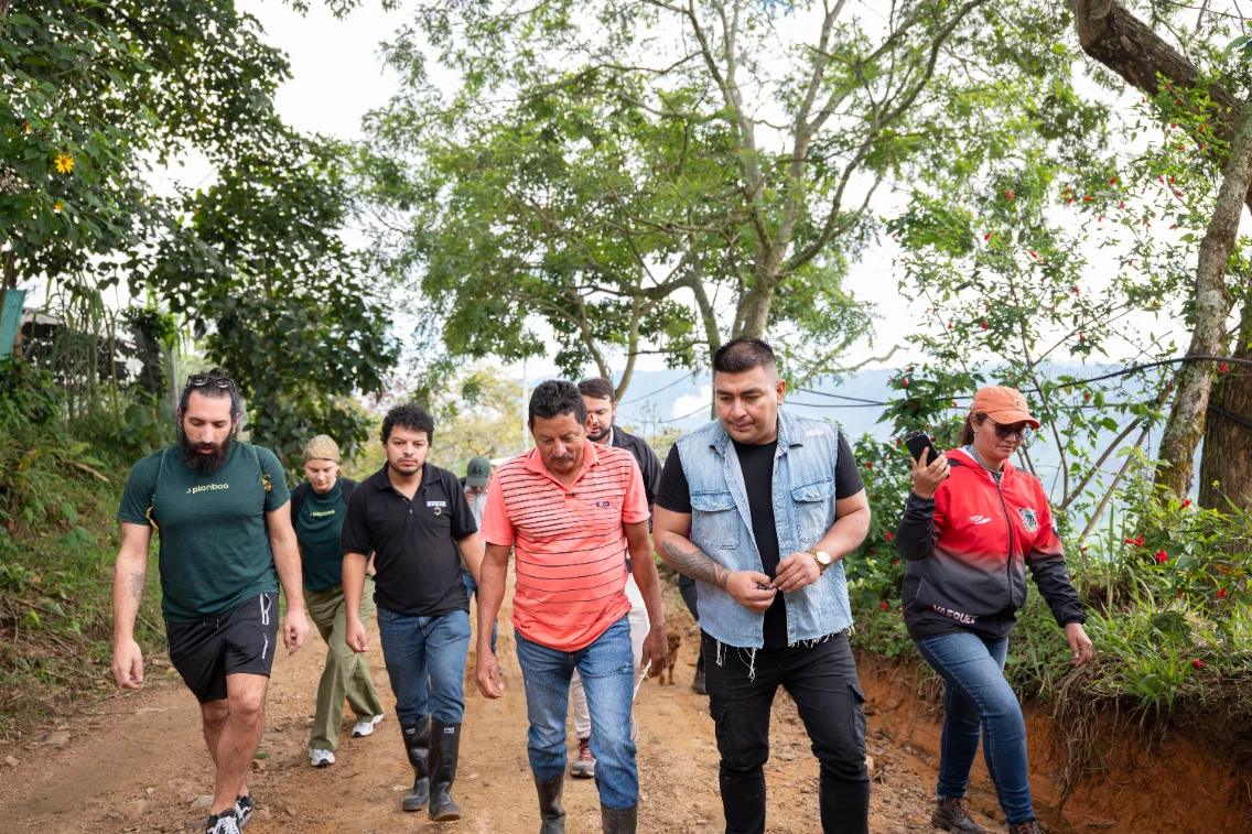 Fabio Mora Rivera walking a farm track with a field team of six other people