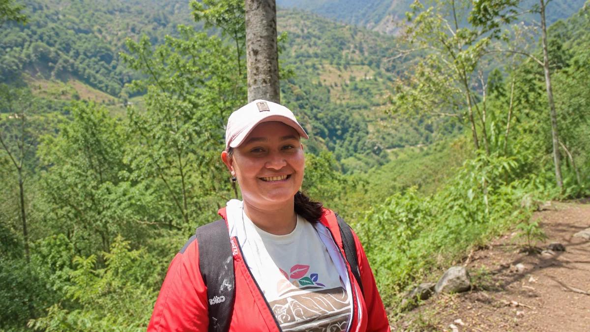 Paola Conde on a ridge in San Fermin, the Tolima hills behind her